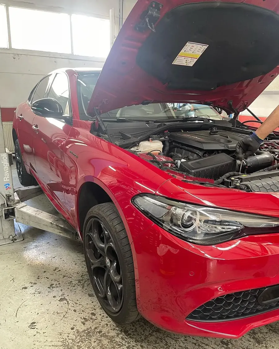 Alfa Romeo Giulia Veloce mit geöffneter Motorhaube auf der Hebebühne bei der Inspektion